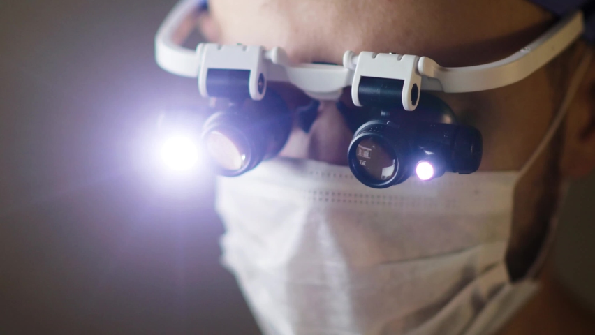 surgeon in professional glasses with illumination operates in the operating room.  doctor is new equipped  technology. Royalty-Free Stock Footage #1059024668