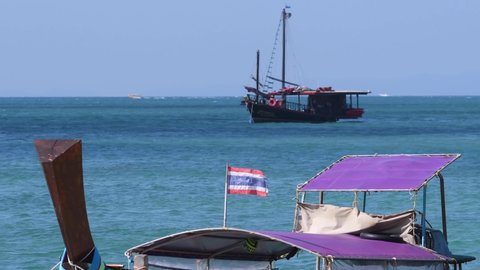 Thai flag on long-tail boat in the sea. Phranang beach, Krabi Province, Thailand. 