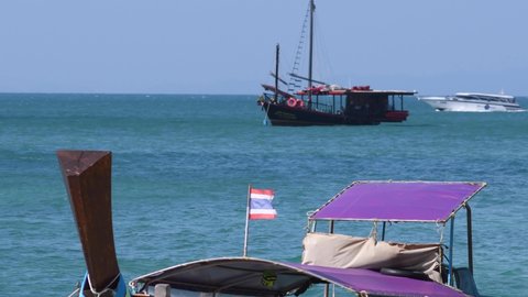 Phranang beach, Krabi Province, Thailand - 28th December, 2019: Vacation in Thailand. Thai flag on the blurry background of long-tail boat.