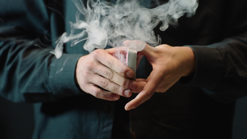 Close-up of a Magician's Hands Performing Card Trick . Throwing and Catching Cards in the Air on black Background with smoke . Card Mechanic .  Shot on ARRI Alexa cinema camera in Slow Motion  Royalty-Free Stock Footage #1059036803