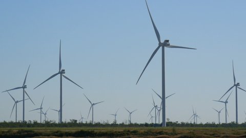 Primorsky Posad, Ukraine - August 13, 2020: Row of a windmill wind turbine spinning against the blue sky. Ecological production of electricity energy. In the field in Ukraine.
