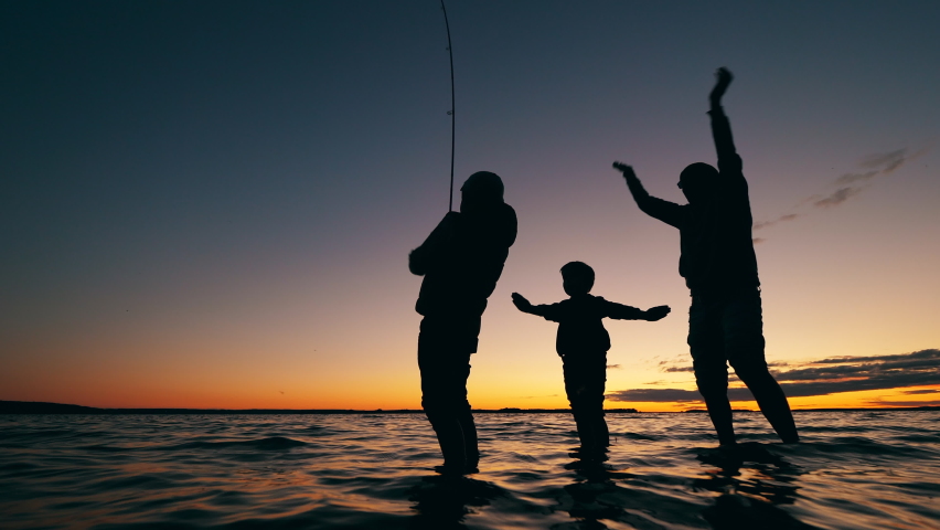 A family are fishing in a sunset lake and having fun