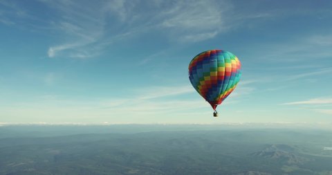 Colorful hot air balloon epic flying above mountain over the fog at sunrise with beautiful sky background - High altitude aerial drone wide view