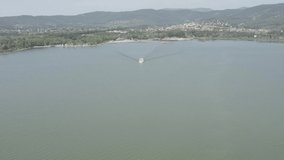 aerial view of a tourist ferry plying the waters of lake trasimeno umbria italy unedited video color dlog-m