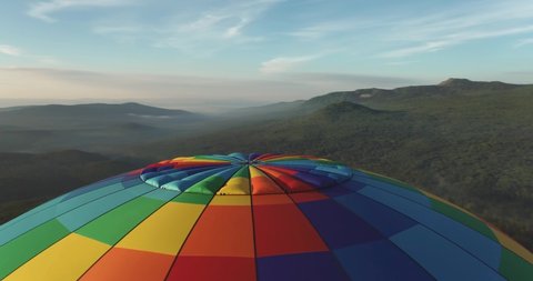 Colorful hot air balloon epic flying above mountain over the fog at sunrise with beautiful sky background - High altitude aerial drone wide view