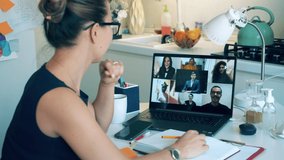 A lady is greeting her colleagues during a video conference call. Meeting online, remote work using videocall.