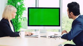Business people in the conference room with green screen chroma key TV or computer on the office table. Diverse group of businessman and businesswoman in meeting on video conference call .