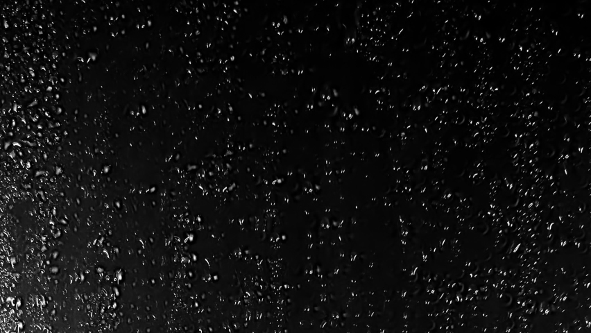 Close up view of Drops of rain trickling down on black background. Perfect Stock Footage for Digital Composing. Water Drops  on black glass background. Royalty-Free Stock Footage #1059065033