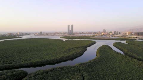 Ras al Khaimah emirate cityscape rising over the mangroves in the United Arab Emirates aerial skyline view at sunset