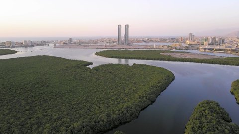 Ras al Khaimah emirate cityscape rising over the mangroves in the United Arab Emirates aerial skyline view at sunset