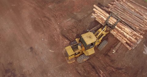 4K Orbiting Aerial Shot of Timber Logging Front loader Vehicle Dropping logs