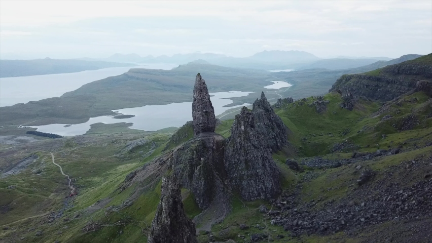 lateral movement drone shot above old man of storr rock formations in isle of skye scotland. Green mountains and lake. beautiful landscape