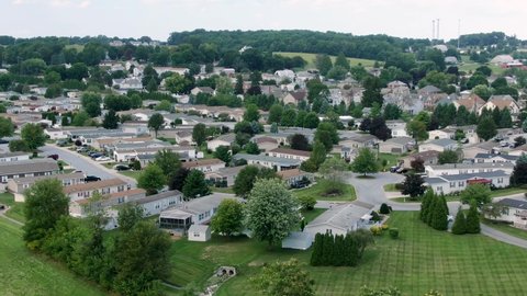 Aerial push-in descending shot on mobile trailer park, manufactured homes, compact small houses in neighborhood community, American town in rural suburbia, USA