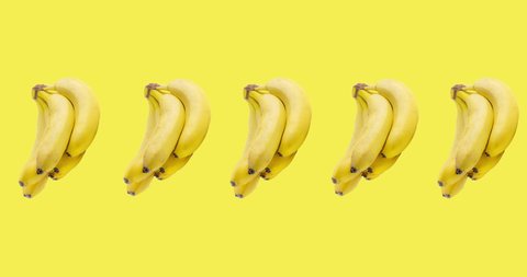 many bunch of bananas animated on yellow background close-up