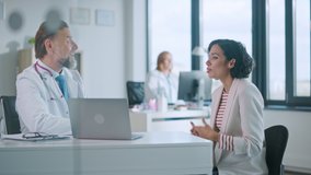 Family Doctor is Delivering Great News About Female Patient's Medical Results During Consultation in a Health Clinic. Physician in White Lab Coat Sitting Behind a Computer in Hospital Office. - Powered by Shutterstock - Get 15% off with code: PIKWIZARD15