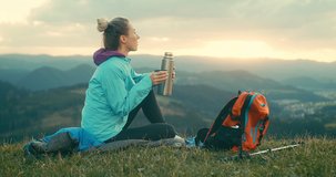 Woman hiker, hiking backpacker traveler camper with her phone camera on the top of mountain in sunny day under sun light. Beautiful mountain landscape view. Hiking, backpacking. 4K slow motion video