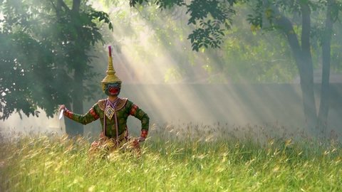 Thailand culture khon performance arts acting entertainment dance traditional costume. Asia acting dancing pantomime show.Actor of green monkey ong kot is performing Ramayana in grass with sun light.