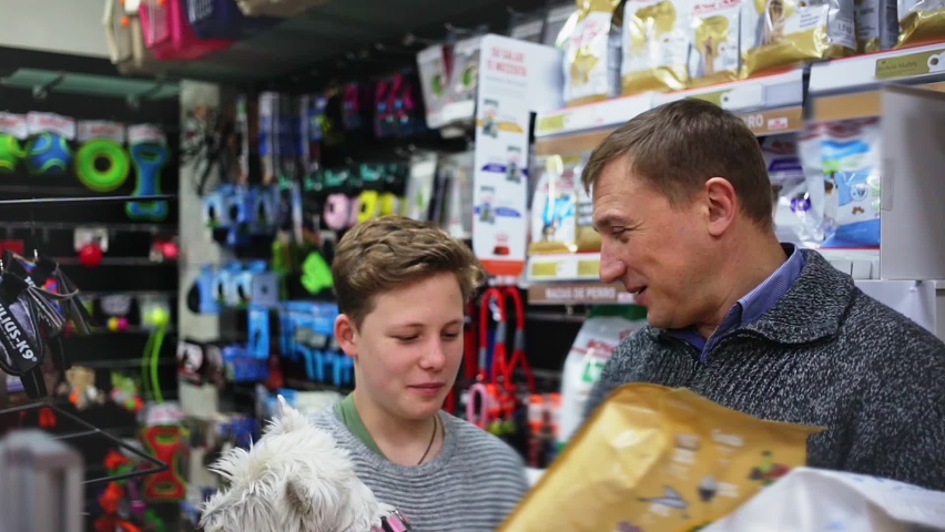 Customers with dog choosing dry food for dogs in pet store Royalty-Free Stock Footage #1059080927