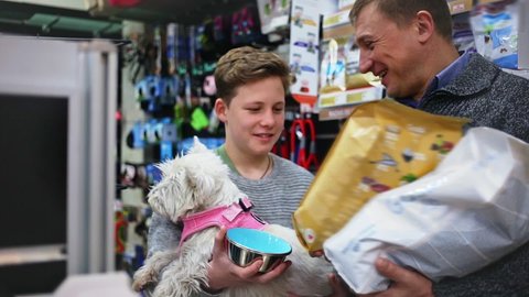 Customers with dog choosing dry food for dogs in pet store