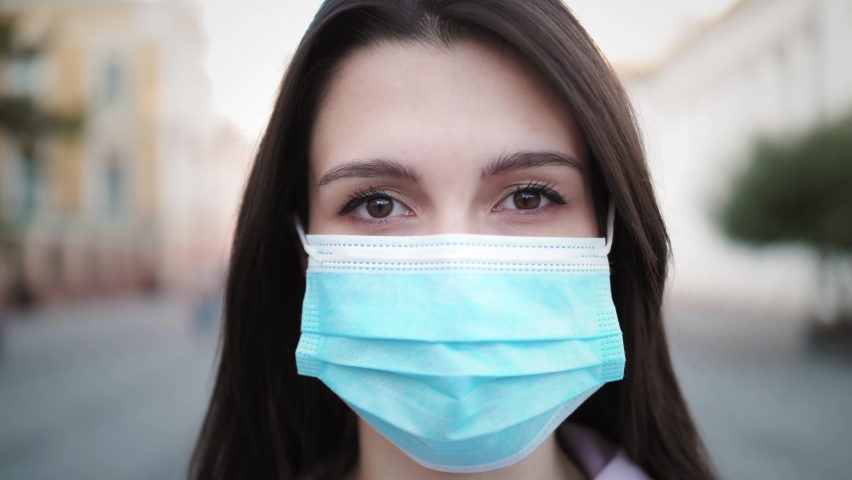 Young hispanic woman taking off protective mask against COVID virus, tourist with medical mask, public space post covid, safe travel after pandemic, student life Royalty-Free Stock Footage #1059082661