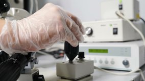Artificial insemination in scientific laboratory under microscope. Fertility specialist performing icsi ivf procedure moving joystick to adjust micromanipulator needles. 4 k video