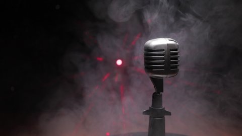 Retro style microphone on background with backlight. Vintage silver Microphone for sound, music, karaoke. Speech broadcast equipment. Live pop, rock musical performance. Selective focus