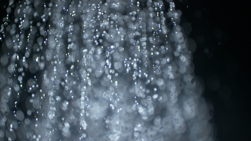 Shower and douche concept overlay highspeed mockup plate shot of downpour water droplets with strong bokeh blur. Fountain of drops in soft selective macro focus and super slow motion against black.  Royalty-Free Stock Footage #1059100406