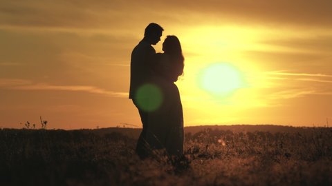 Enamored man and woman dance in bright rays of sun in field on meadow. carefree family dancing at sunset on beach. Happy guy and woman waltz in evening in a summer park. happy free people.