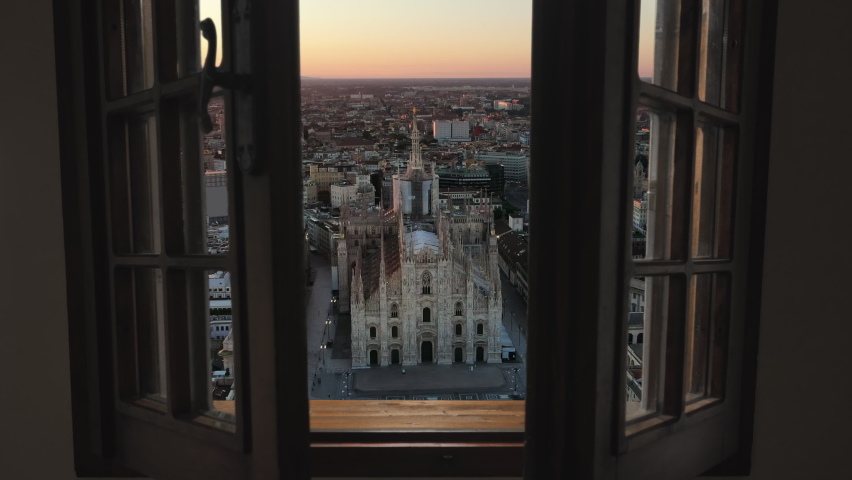 Milan cathedral piazza del duomo aerial view, drone moving out from inside house through the window at sunrise Royalty-Free Stock Footage #1059103619