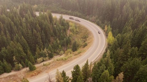 4k aerial footage of vehicles driving on a highway in a mountainous terrain