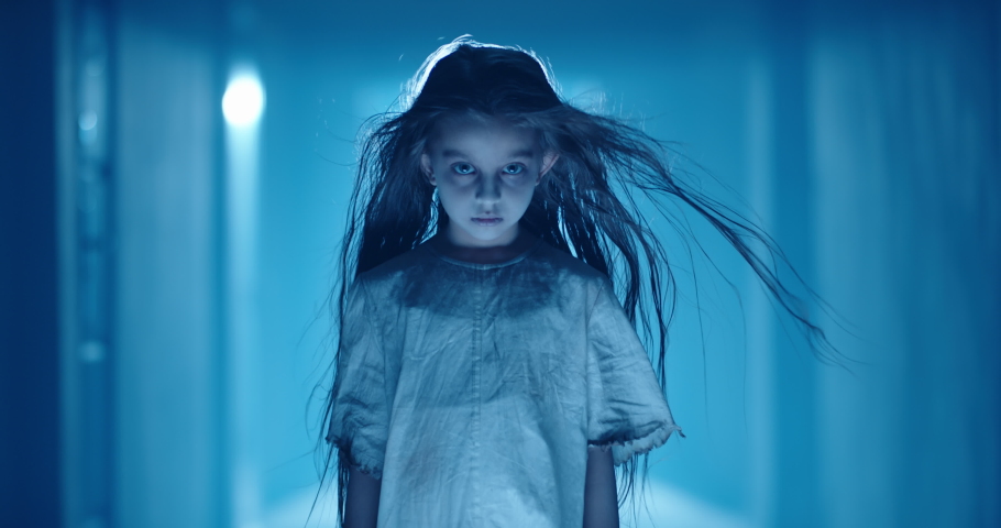 Little caucasian girl in ghost white sundress costume for halloween party creepily staring at camera while mistique wind blows her hair 4k footage | Shutterstock HD Video #1059107894