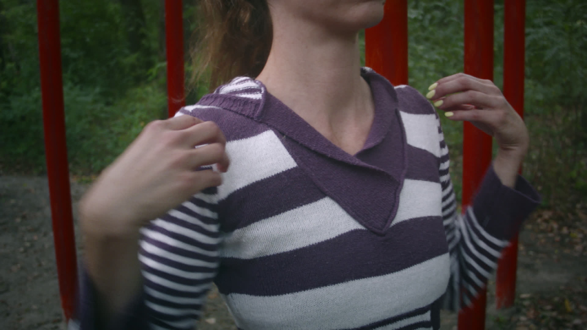 Young caucasian woman doing sports on the playground in the forest on a cloudy day. Woman doing exercise on the sports ground.