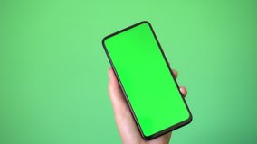 woman's hand holding a mobile telephone with a vertical green screen in tram chroma key smartphone technology cell phone touch message