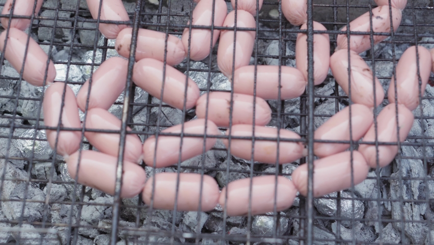 Cafes and restaurants, cooking, picnic, oriental kitchen concept - close-up cold cuts sausages on barbecue grill strung on skewer smoked and fried on roasted coals. Outdoor men