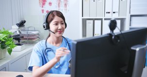 Telemedicine concept - asian female doctor wear headset talking to patient online and writing down the notes on digital tablet
