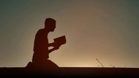Man reading religious book at evening