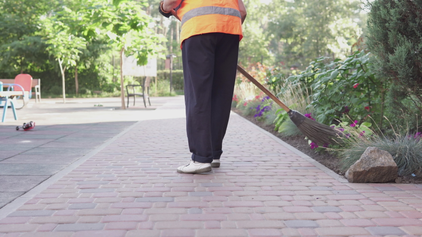 A cleaning lady on the street removes garbage. Cleanliness and order in the yard depends on the janitor during quarantine.	
 | Shutterstock HD Video #1059123089
