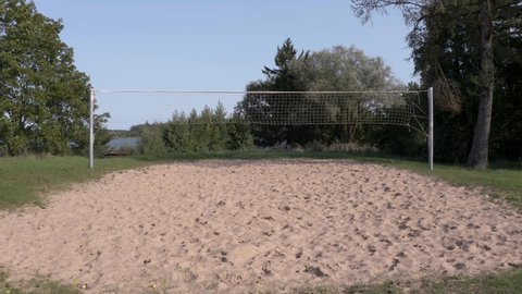 Flying with drone under volleyball net on a sunny day. Flying close to the sand with a drone.