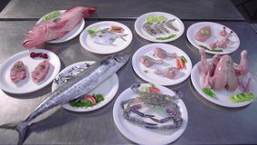 Raw sea food and raw meat served on plate.All different kind of meat kept on table.Exhibiting/Plating different kind of raw meat.
