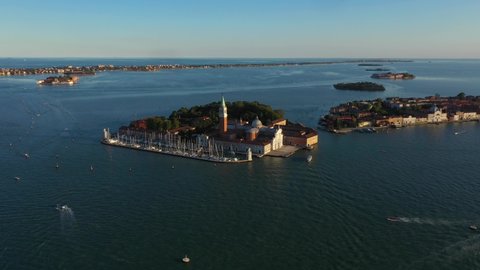 Aerial view flying to Church of San Giorgio Maggiore during sunset in Venice in Italy in 4k.
