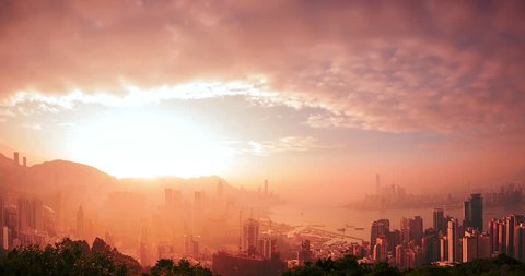 Hong Kong skyline timelapse of  from day to night. Amazing panoramic view of modern city with sun light rays shining through clouds at sunset