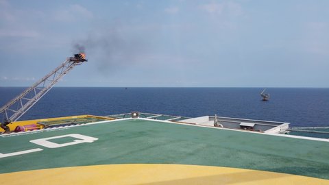 Helicopter landing on a helideck of an offshore oil rig, service travel to oil and gas platform and drilling rig in offshore locations

