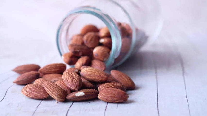 Close up of almond nut spilling from a container  | Shutterstock HD Video #1059137045