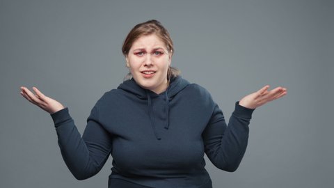 Video of confused stout woman in sweatshirt