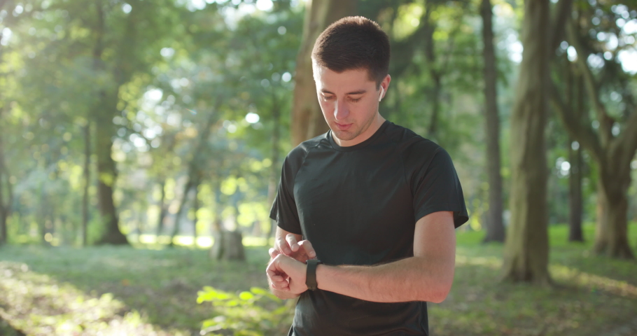 Man runner using smart watch. Handsome guy tracking result after workout. Portrait of fitness man checking result. Sport man looking smart watch. Royalty-Free Stock Footage #1059143744