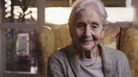 beautiful old lady portrait looking in camera with intense face sitting in the living room of her house in yellow armchair at golden hour, 90 years old healthy elderly woman. Slow motion parallax shot - Powered by Shutterstock - Get 15% off with code: PIKWIZARD15