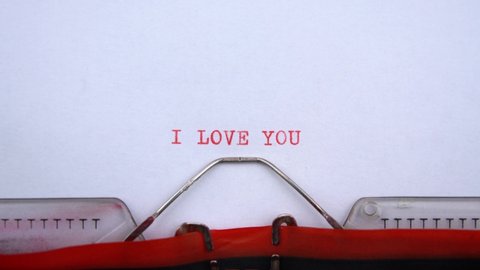 I love you - phrase printed on an old typewriter in red letters, close up. vintage inscription