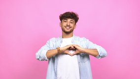 Young arab man doing a heart with hands, expressing the concept of love and friendship