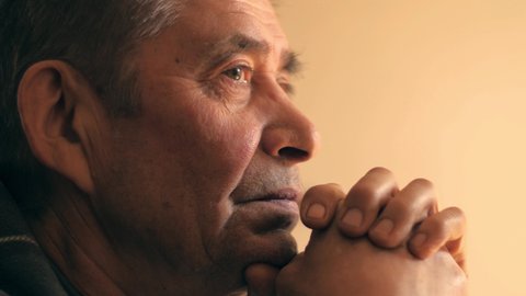 Senior man at home, looking up, praying prayer, thinking. Portrait, closeup, 4K UHD.