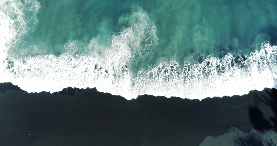 Top down aerial view from drone of nature volcanic black sand beach and beautiful waves. Royalty-Free Stock Footage #1059154268
